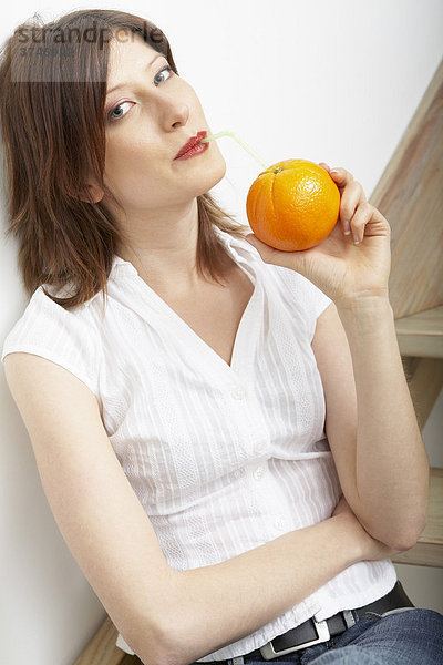 Frau trinkt reinen Orangensaft