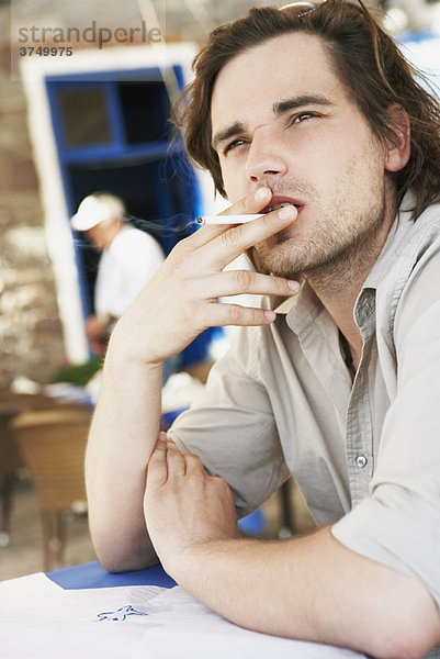 Mann raucht Zigarette im Restaurant