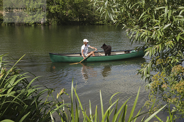 Frau im Kanu mit Hund