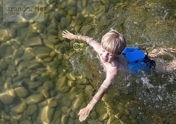 Schwimmender Junge mit Schwimmgürtel