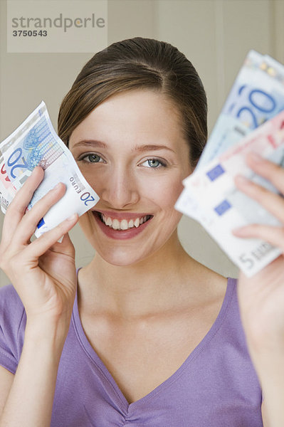 Porträt einer glücklichen Frau mit Geld