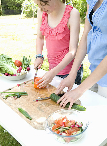 Mutter und Tochter bereiten Salat in gdn zu.