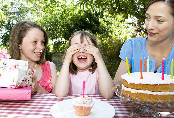 Kleines Mädchen wartet auf Kuchen und Geschenke