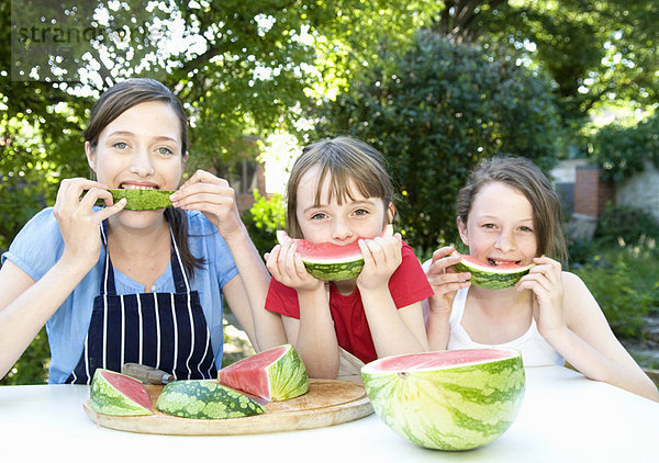 Mutter und Töchter essen Wassermelone