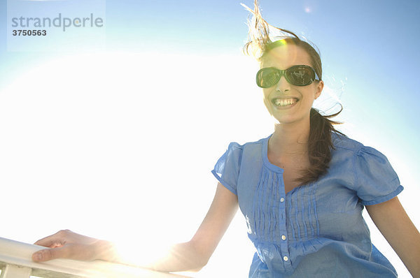 Schicke Frau im Sonnenlicht schaut zur Kamera