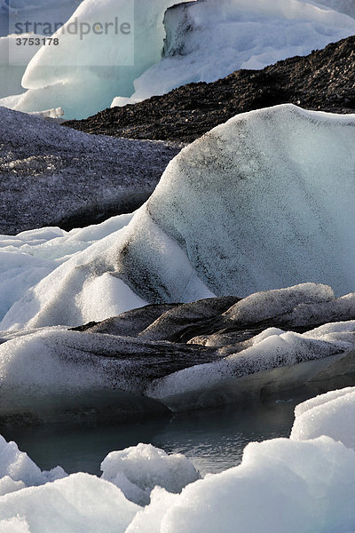 Eisberge deren unterschiedliche Färbung bis hin zu schwarz von Vulkanasche herrührt  Gletschersee Jökulsarlon  Südküste  Island