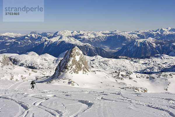 Schifahrerin fährt über den verschneiten Dachsteingletscher und der Berg Schöberl (2426m) rechts daneben Simonyhütte  Dachstein  Steiermark  Österreich