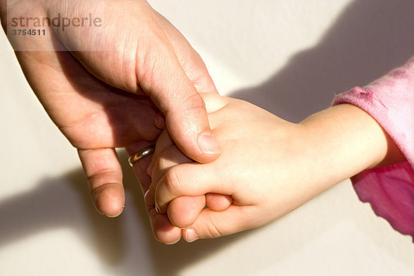 Hand eines Vaters und seiner Tochter