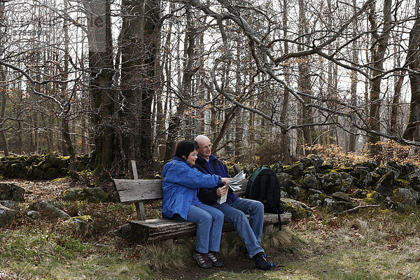 Paar sitzt auf Bank und liest Landkarte  Lange Rhön  Unterfranken  Bayern  Deutschland  Europa