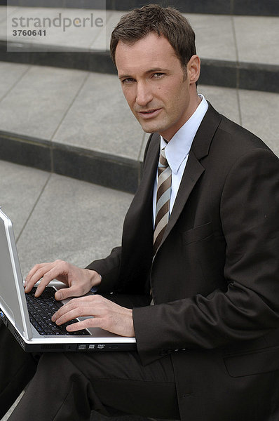 31-jähriger Business Mann im Anzug mit Laptop