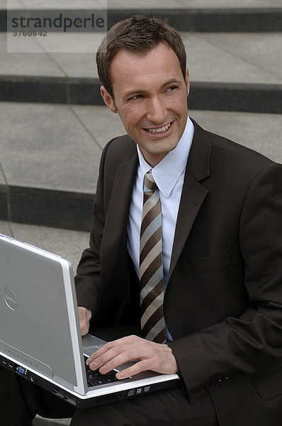 31-jähriger Business Mann im Anzug mit Laptop
