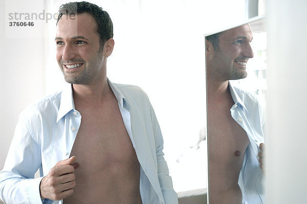 31-jähriger Mann mit offenem Hemd beim Anziehen
