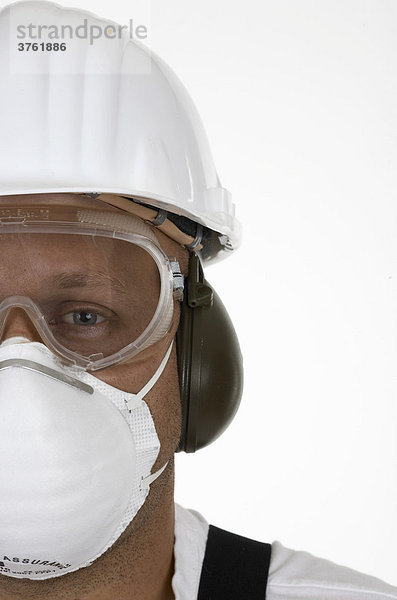 Handwerker mit Helm  Schutzbrille  Mundschutz und Gehörschutz (Arbeitssicherheit)