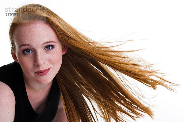 Portrait einer rothaarigen mit Sommersprossen und wehenden Haaren