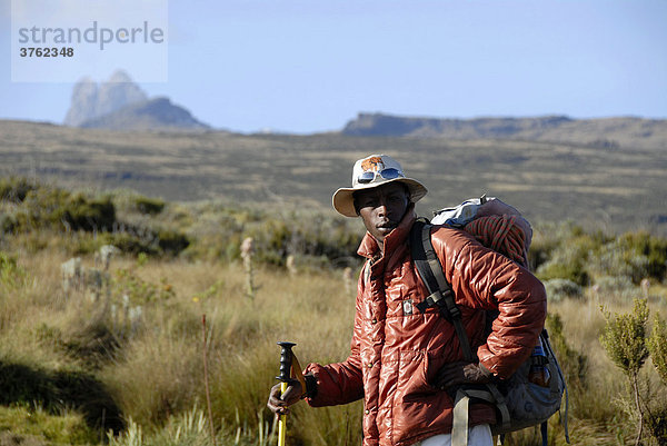 Einheimischer Führer in Heidelandschaft vor Gipfel des Batian (5199 m) Mount Kenia Nationalpark Kenia