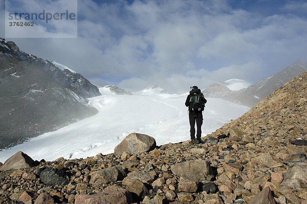 Bergsteiger steht auf Geröll vor Gletscher Kharkhiraa Mongolischer Altai bei Ulaangom Uvs Aimag Mongolei