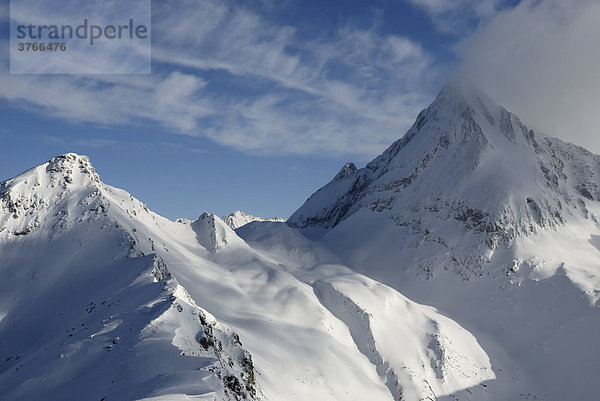 Abendliche Stimmung mit Föhnwolken über schneebedeckten Berggipfeln Torhelm und Brandenberger Kolm Zillertaler Alpen Tirol Österreich