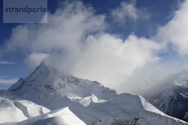 Nebelschwaden ziehen über einen schneebedeckten Bergkamm und Berggipfel  Zillertaler ALpen Tirol Österreich