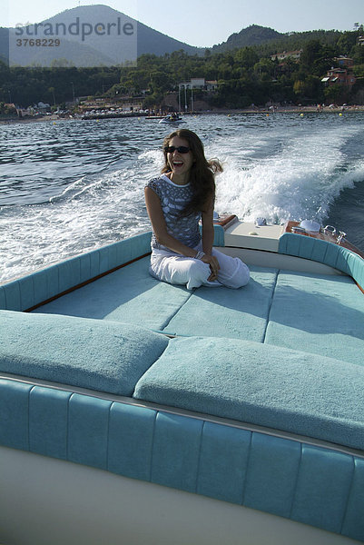 Junge Frau auf der Liegefläche eines Riva Motorboots bei voller Fahrt  ThÈoule-sur-Mer  Frankreich  Europa