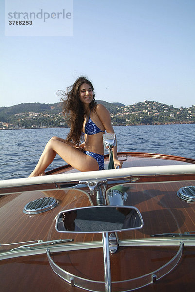 Junge Frau im Bikini sonnt sich auf der Bugspitze eines Riva Motorboots  ThÈoule-sur-Mer  Frankreich  Europa
