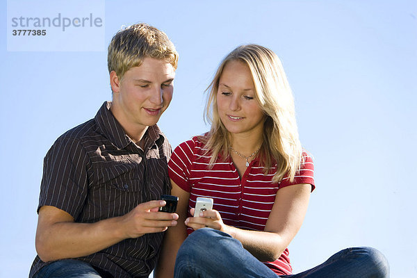 Ein junges Paar  er 22  sie 20  beide mit Handy