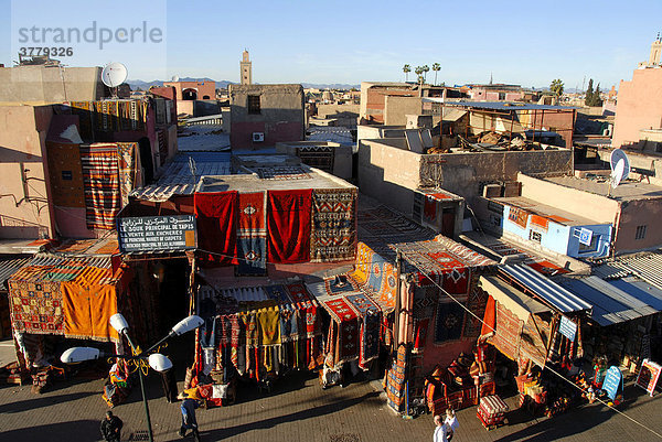 Blick über die Dächer der Stadt Teppiche hängen vor den Fassanden Place Rahba Kedima Medina Marrakech Marokko