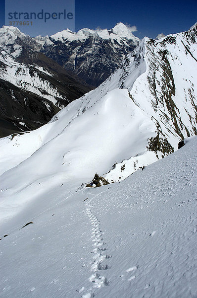 Fußspuren im Schnee oberhalb des Kang La Passes mit Berg Kang Guru im Hintergrund Nar-Phu Annapurna Region Nepal