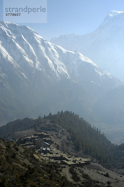 Blick auf das Dorf Ngawal mit dunstigem Tal und schneebedeckten Bergen Annapurna Region Nepal