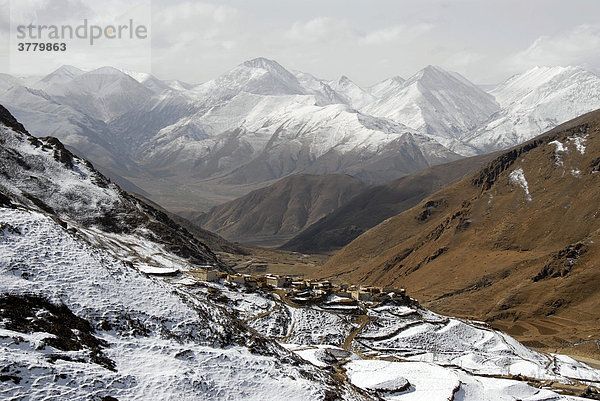 Dorf auf schneebedecktem Hang und Berge Yerpa Tibet China