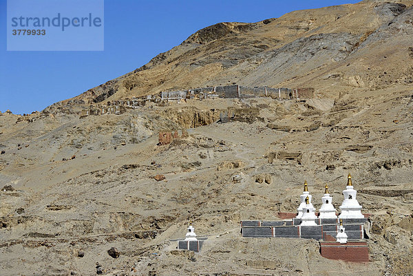 Tibetischer Buddhismus verfallene Anlage über weißen Stupas mit grau und dunkelrot gestrichener Mauer Kloster Sakya Tibet China