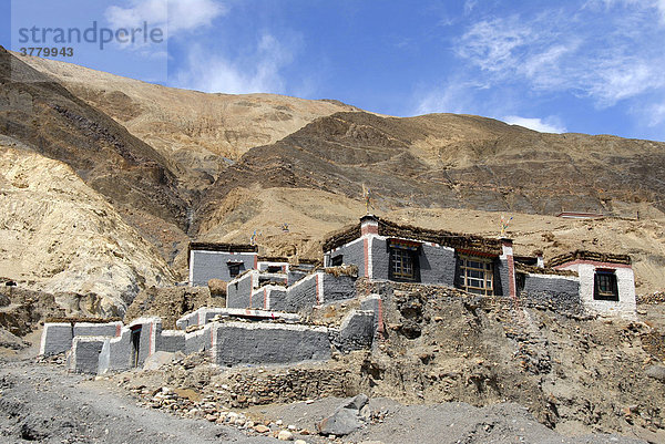 Traditionelle Häuser mit grau und dunkelrot gestrichener Mauer an Berghang Kloster Sakya Tibet China