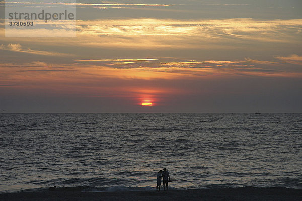 Ein Paar schaut sich den Sonnenuntergang auf Sylt an  Sylt  Schleswig-Holstein  Deutschland