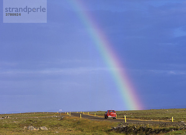 Rotes Auto einsame straße und Regenbogen  Hraunhafnartangi  Nordisland  Island