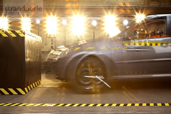 Crashtestwagen mit einem Crashtest-Dummy  der in eine Schranke fährt