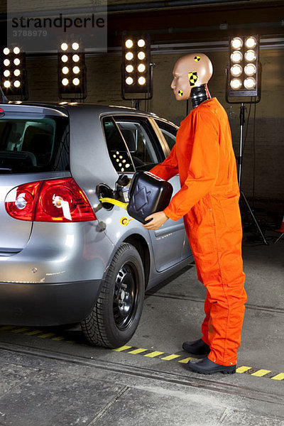 Ein Crashtest-Dummy  der Gas in ein Auto gibt.