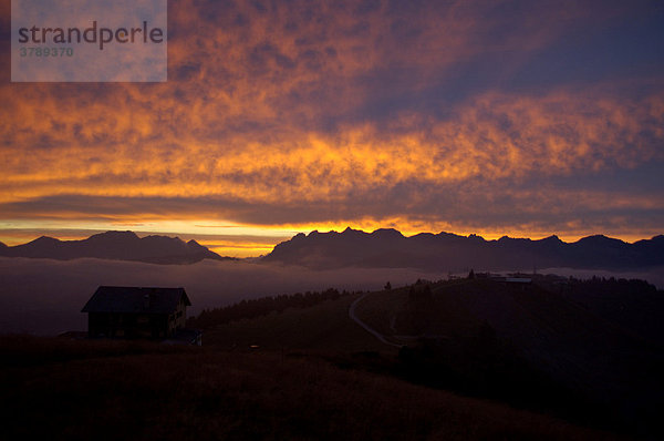 Abendhimmel mit leuchtend rosafarbenen Wolken über Berghütte und Gebirge Hochsavoyen Haute-Savoie Frankreich