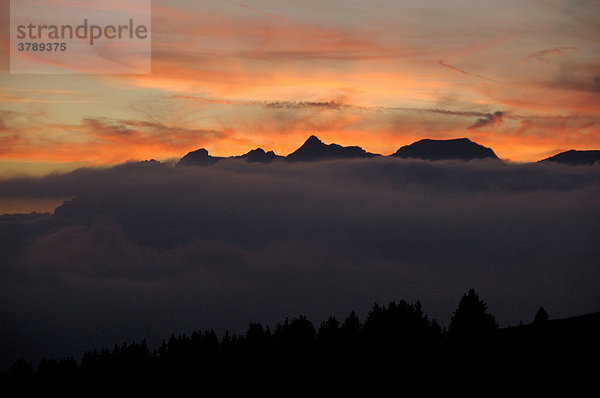 Abendhimmel mit leuchtend rosafarbenen Wolken über Gebirge und Wald Hochsavoyen Haute-Savoie Frankreich
