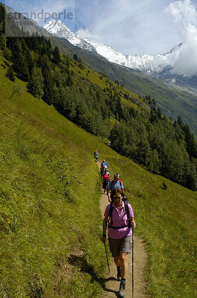 Wandergruppe wandert im Gänsemarsch auf einem Pfad an Wiesenhang Hochsavoyen Haute-Savoie Frankreich