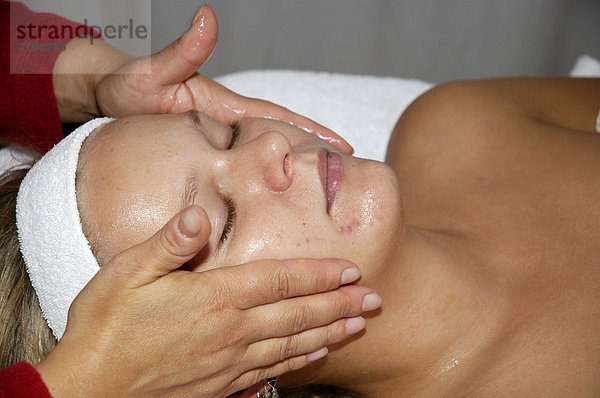 Junge Frau entspannt sich bei einer Massage  Kosmetik  Kosmetikbehandlung  Koerperpflege  Gesichtsmassage