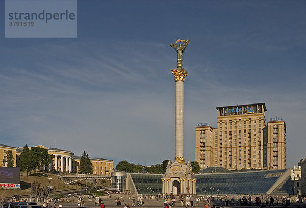 Ukraine Kiev Unabhängigkeits Denkmal 63 m hoch mit der Frauenfigur - Ruhm für die Ukraine - Mamorsäule ukrainischer Barockstil mit weißem Marmor Besucher und Touristen auf dem Platz Hotel Kiev rechts Zovtnevyj -Palast links blauer Himmel 2004