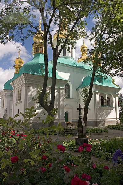 Ukraine Kiev das Höhlenkloster Kyjevo Pecers¥ka Lavra Blick auf die Gottesmutter Geburtskirche im Vordergrund Gräber Blumen und Bäume blauer Himmel und Wolken 2004