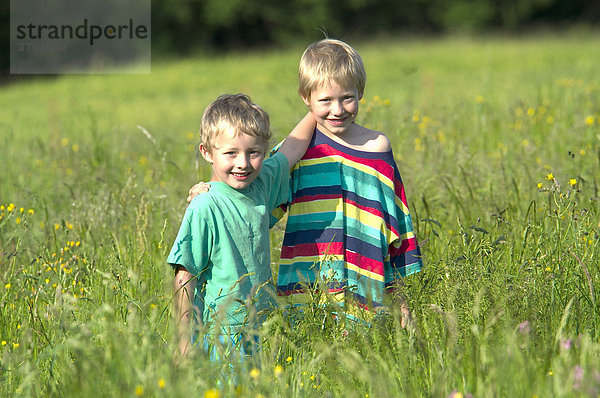 Zwei kleine Jungen stehen in Blumenwiese