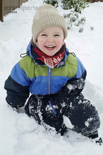 Kleiner junge spielt im schnee