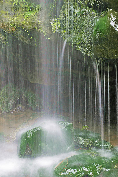 Kleiner Wasserfall  Wasser läuft über bemooste Steine