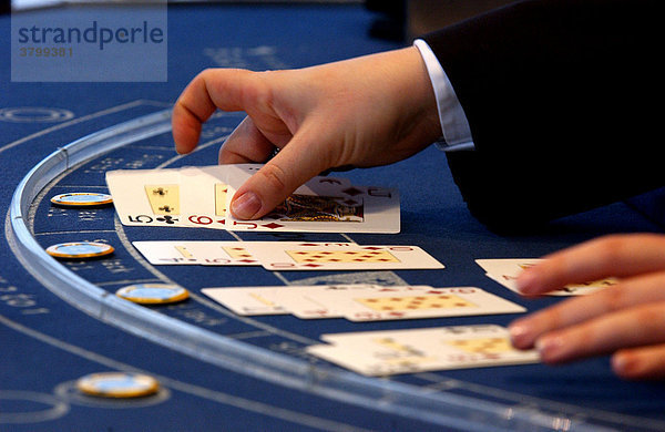 Spiel Casino im 37. Stock des Forum Hotel in Berlin Mitte. Haende beim Mischen von Karten und sortieren von Chips bei Black Jack und Roulette.