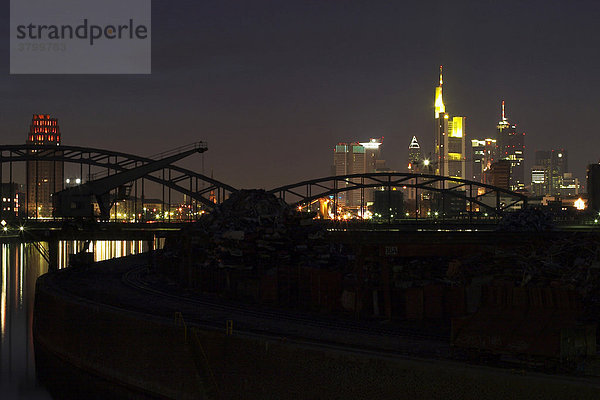 Großartige Skyline von Frankfurt am Main mit den Wolkenkratzern der Banken bei Nacht mit einer Eisenbahnbrücke im Vordergrund
