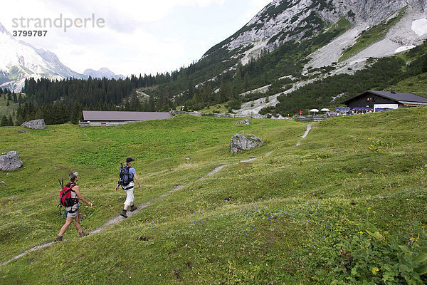 Klettersteigeherinnen im Sommer in der Nähe von Ehrwald (Österreich) kurz vor dem Erreichen einer Almhütte