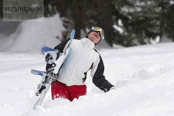 Lachende Snowboarderin beim Kampf durch hüfthohe Schneemassen (Saalbach  Österreich)