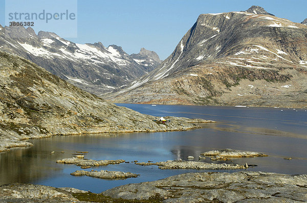 Zeltlager in glazialer Berglandschaft Bucht mit Schären und schneebedeckten Bergen am Sermilik Fjord bei Tiniteqilaaq Ostgrönland