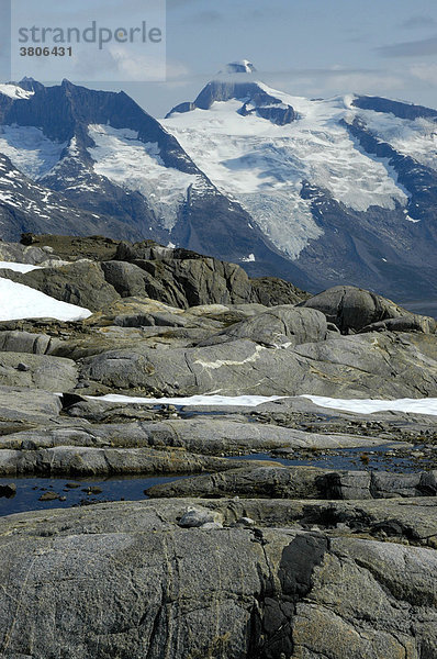 Blick über Schneefelder Felsen auf schneebedeckte Berge Ostgrönland
